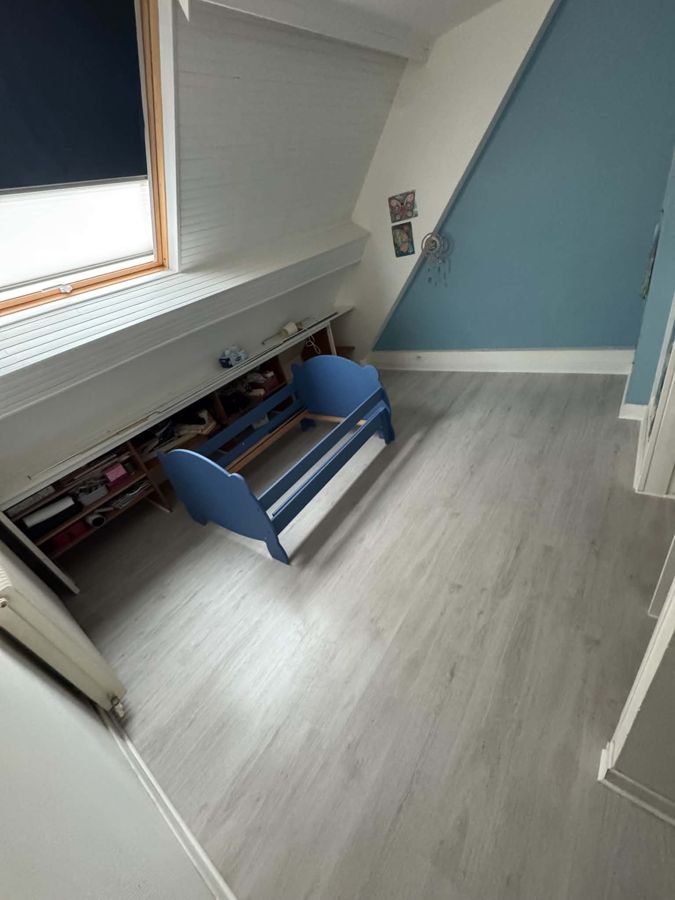 Pose de sol stratifié gris clair dans une chambre sous combles – RUSHITI Rénovation, Besançon