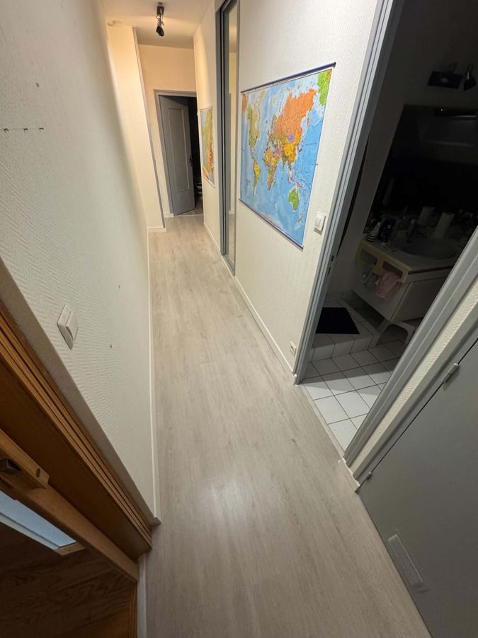Pose de sol stratifié chêne clair et plinthes blanches dans un couloir – RUSHITI Rénovation, Besançon