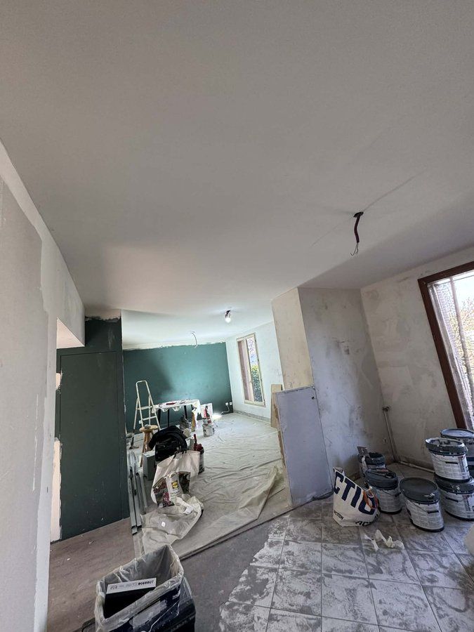 Murs et plafond ratissés avant mise en peinture sur un chantier à Besançon
